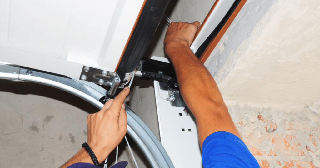 Worker repairing a garage door mechanism.